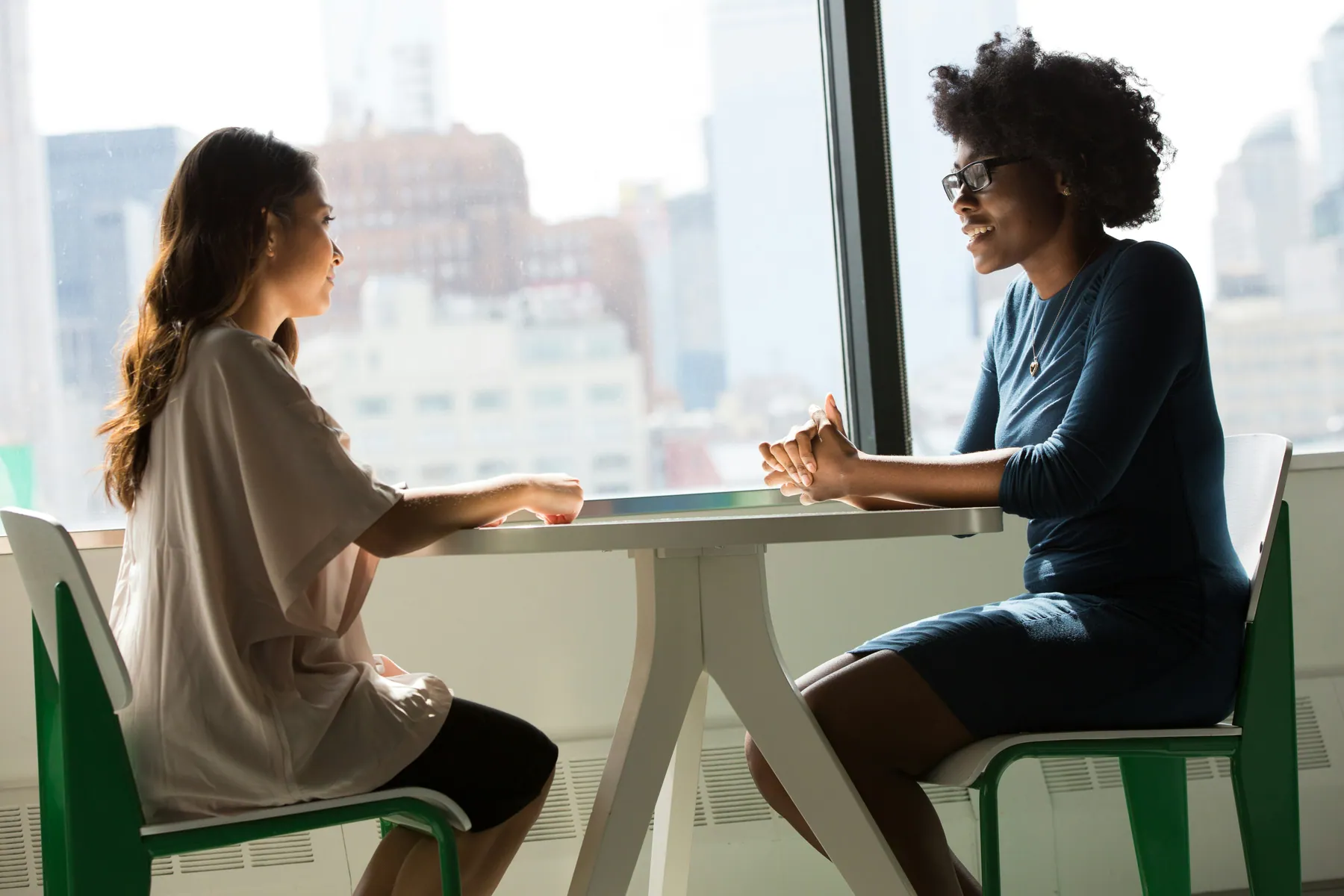 A therapist and client talking together in a bright, welcoming room